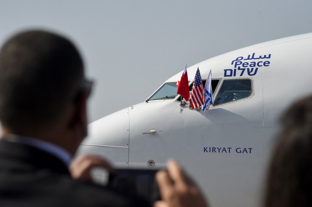 Les drapeaux de Bahreïn, d’Israël et des États-Unis flottent sur un avion Boeing 737 de la compagnie aérienne israélienne El Al, au moment où il atterrit sur une piste de l’aéroport international du royaume de Bahreïn, le 18 octobre 2020. On peut lire au niveau du cockpit le mot «paix» écrit en arabe, en anglais et en hébreu. (Photo, AFP)