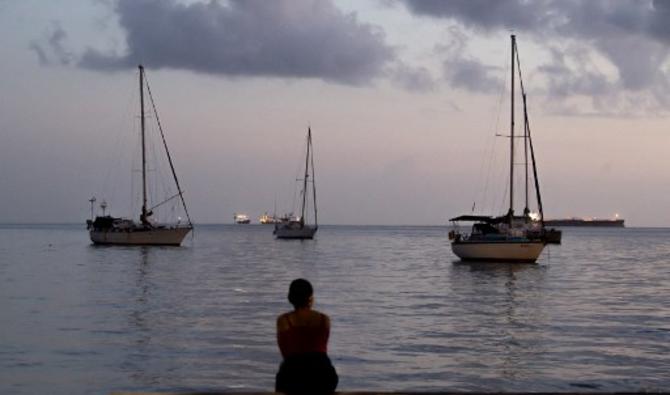 Une femme assise sur le front de mer avant le couvre-feu à Fort-de-France sur l'île des Caraïbes françaises de la Martinique, le 30 août 2021. (Photo, AFP)