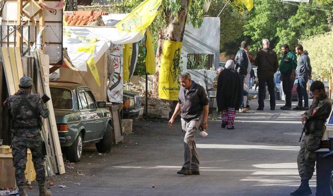 Des Palestiniens armés montent la garde près du site d'une explosion à l'intérieur du camp de réfugiés palestiniens de Burj al-Shemali à l'extérieur de la ville portuaire de Tyr, dans le sud du Liban, le 11 décembre 2021. (Photo, AFP) 