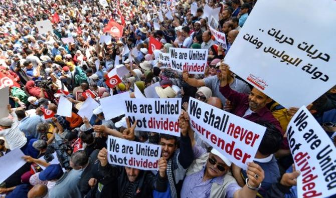 Des manifestants tunisiens agitent des drapeaux alors qu'ils manifestent contre leur président dans la capitale Tunis, le 15 mai 2022. (Photo, AFP)