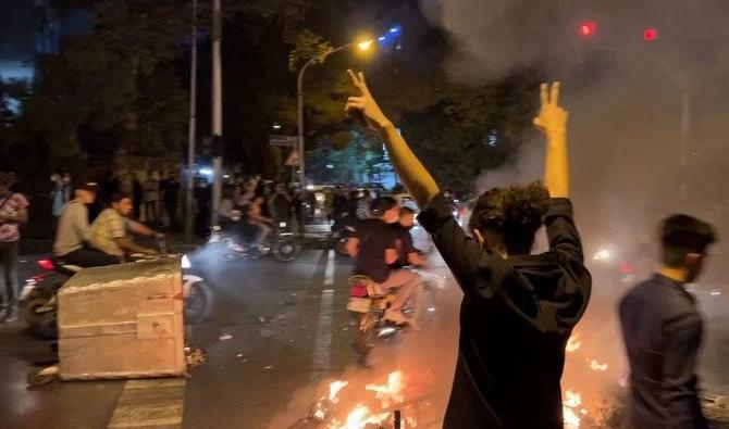Un manifestant lève les bras et fait le signe de la victoire lors d'une manifestation antigouvernementale pour Mahsa Amini à Téhéran. (Fichier, AFP)